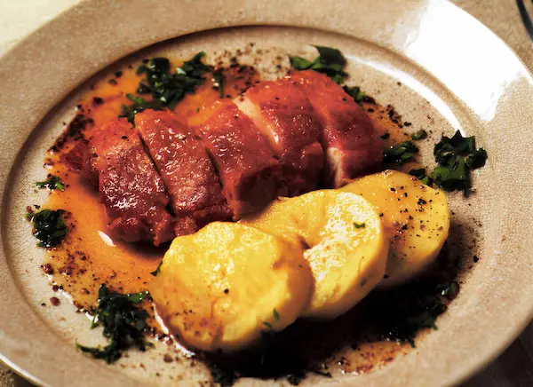 調味料の働きを探究教育で考える鶏肉のお酢ソテーのレシピ。焼き色のついた鶏肉と付け合わせを盛り付けた写真